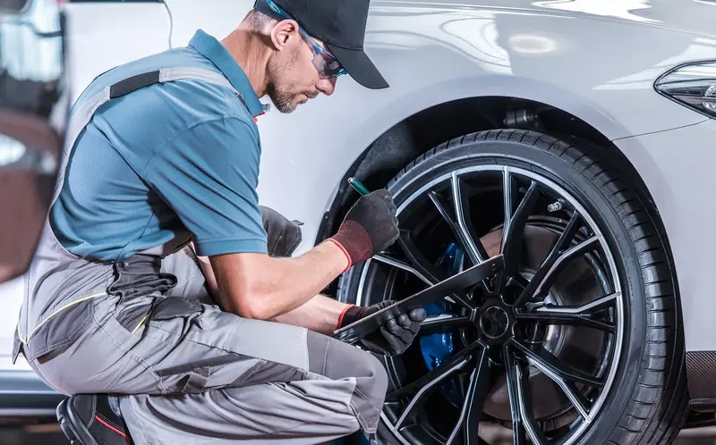 Mecânico apertando os parafusos da roda de um carro