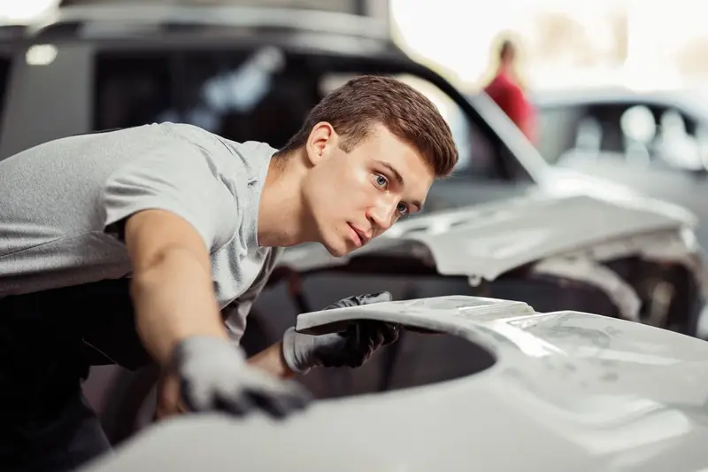 Mecânico avaliando um carro na oficina da Gênesis Mecânica